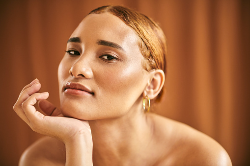 Skincare, beauty and woman with face makeup against a brown background. Portrait of a calm, relax and African girl model with cosmetics for skin, facial dermatology and wellness with mock up space