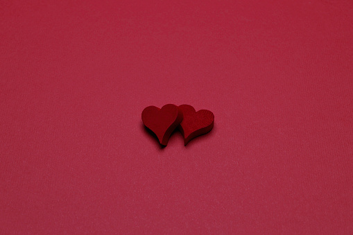 red wooden hearts on the red background