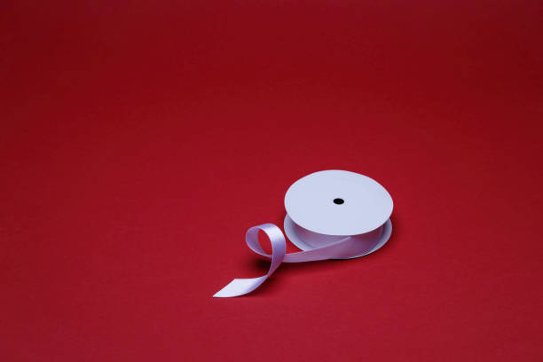 istock a spool with white decorative ribbon on the red background 1438680871