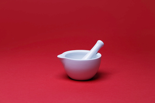 white ceramic mortar on the red background