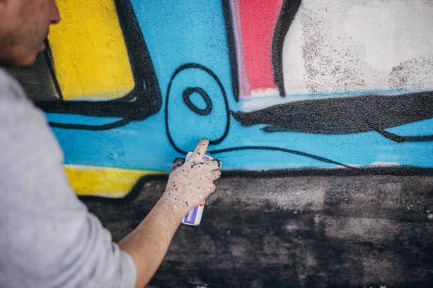 istock Artist painting graffiti on wall 1438684271