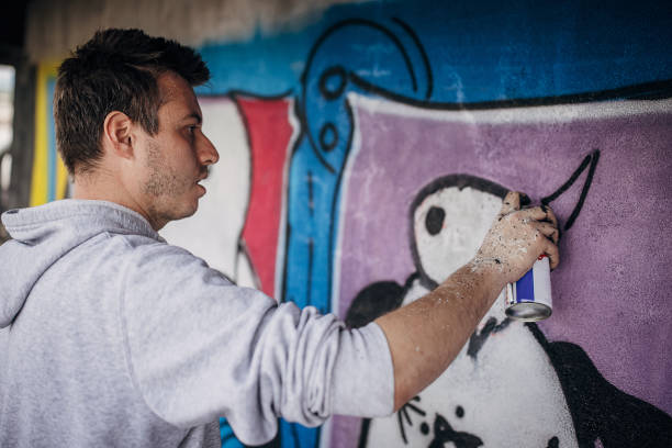 istock Artist painting graffiti on wall 1438684304