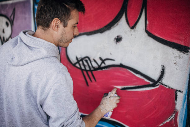 istock Artist painting graffiti on wall 1438684316