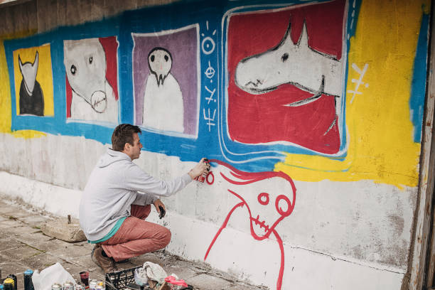 istock Artist painting graffiti on wall 1438684439