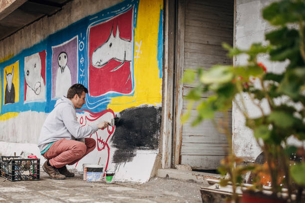 istock Artist painting graffiti on wall 1438685300