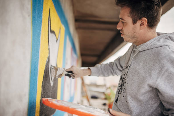 istock Artist painting graffiti on wall 1438686474