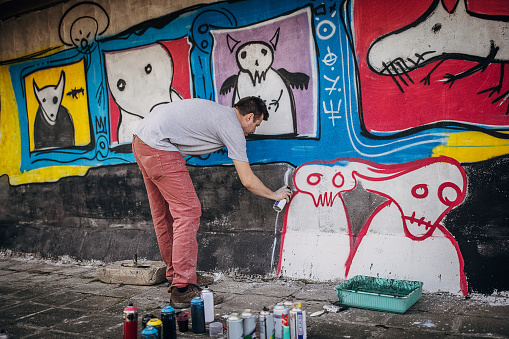 Athens, Greece - October 9, 2011: Distant pedestrian in front of graffiti wall at \\\
