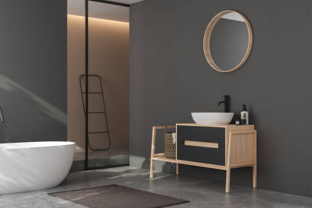 istock Modern minimalist bathroom interior, modern bathroom cabinet, white sink, wooden vanity, interior plants, bathroom accessories, bathtub and shower, black and beige walls, concrete floor. 3d rendering 1438687490