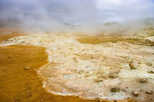 Hverir and myvatn geothermal spot with bubbling mud and steaming fumaroles emitting sulfuric gas.