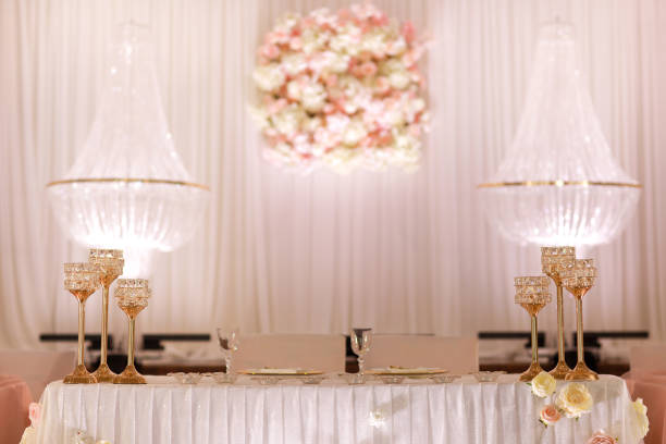 festive wedding table decoration with crystal chandeliers, golden candlesticks, candles and white pink flowers . stylish wedding day. festive wedding table decoration with crystal chandeliers, golden candlesticks, candles and white pink flowers . stylish wedding day wedding hall stock pictures, royalty-free photos & images