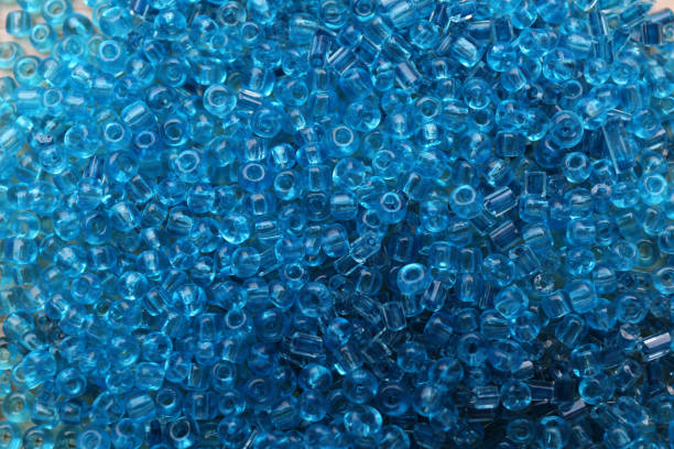 istock Bright light blue glass beads as background, top view 1438689987