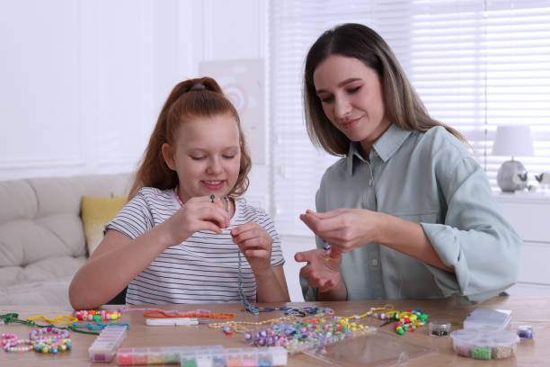 집에서 구슬 보석을 만드는 딸과 함께 행복한 어머니 - bead glass making jewelry 뉴스 사진 이미지