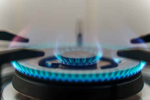 Kitchen stove with blue flames burning. Blue flames from gas stove burner.