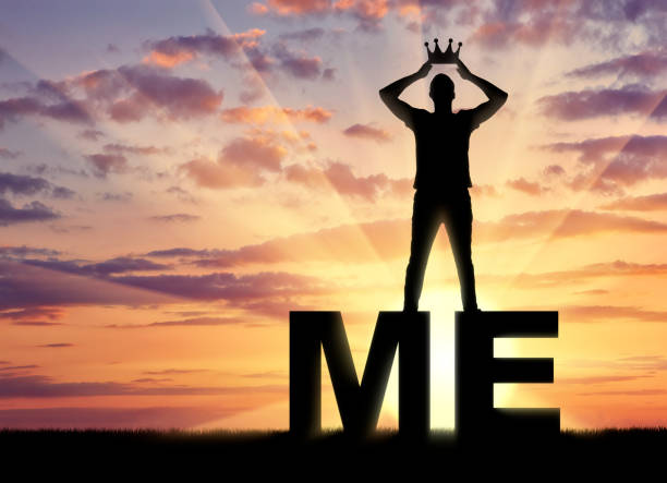 Concept of narcissism and selfishness. The silhouette of a selfish and narcissistic man reconciling himself with a crown on the word me