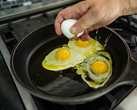 Man Frying Egg in a Cooking Pan
