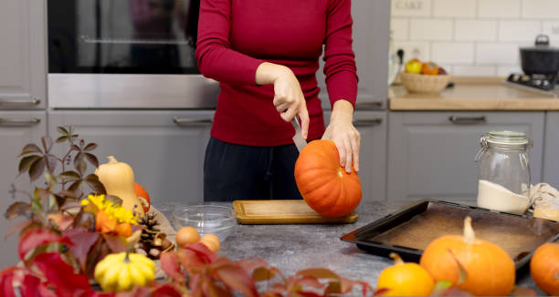 istock The girl cuts a beautiful ripe pumpkin. 1438696375