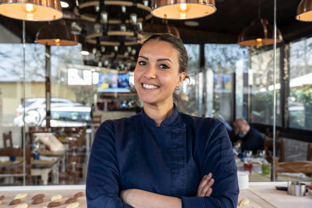 Young north african chef woman smiling on camera at the restaurant - Focus on face Young north african chef woman smiling on camera at the restaurant - Focus on face moroccan woman stock pictures, royalty-free photos & images