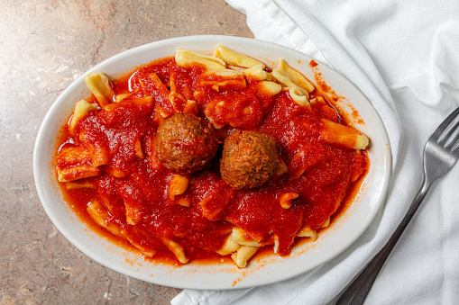 Tagliatelle with meatballs and tomato sauce on dark background. Italian food concept. Top view, copy space