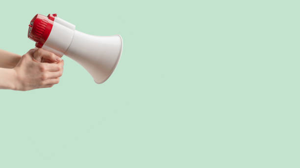istock Megaphone in woman hands on a white background. 1438698531