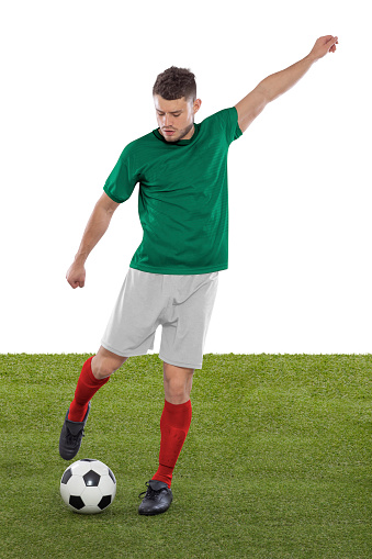 Professional soccer player with green Mexico national team jersey about to score a goal with an expression of challenge and decision on his face on white background.
