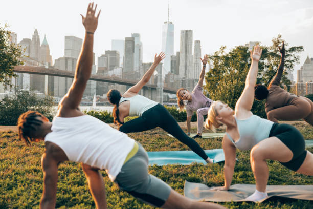 cours de yoga en plein air à new york - yoga class caucasian young adult group of people photos et images de collection