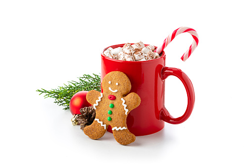 Close up view of a red mug filled with hot chocolate, candy cane and marshmallows isolated on white background. A gingerbread man cookie and Christmas decoration complete the composition. Copy space available. High resolution 42Mp studio digital capture taken with Sony A7rII and Sony FE 90mm f2.8 macro G OSS lens