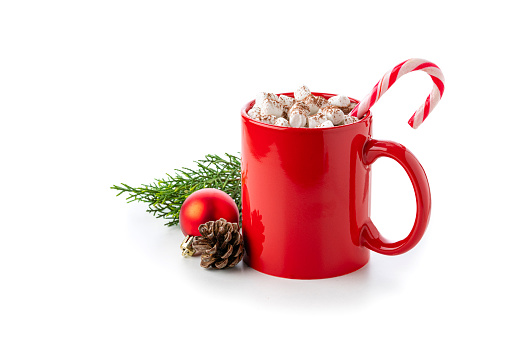 Close up view of a red mug filled with hot chocolate, candy cane and marshmallows isolated on white background. Christmas decoration complete the composition. Copy space available. High resolution 42Mp studio digital capture taken with Sony A7rII and Sony FE 90mm f2.8 macro G OSS lens