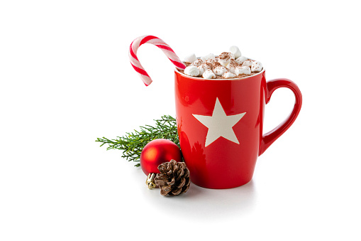 Close up view of a red mug filled with hot chocolate, candy cane and marshmallows isolated on white background. Christmas decoration complete the composition. Copy space available. High resolution 42Mp studio digital capture taken with Sony A7rII and Sony FE 90mm f2.8 macro G OSS lens