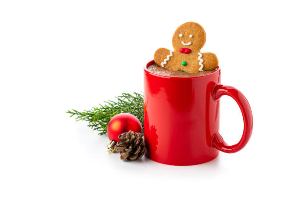 Close up view of a red mug filled with hot chocolate and gingerbread man cookie isolated on white background. Christmas decoration complete the composition. Copy space available. High resolution 42Mp studio digital capture taken with Sony A7rII and Sony FE 90mm f2.8 macro G OSS lens
