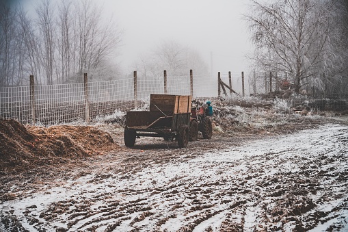 A snowy field with a wagon attached to a four-wheel motorcycle