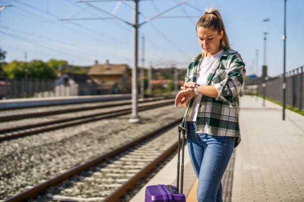 Woman looking at clock while standing on a train station stock photo