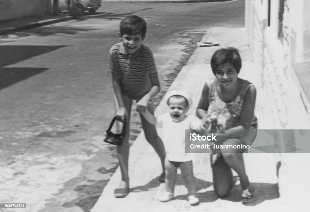 Black and white Image taken in the 60s: children Siblings posing together Family Stock Photo