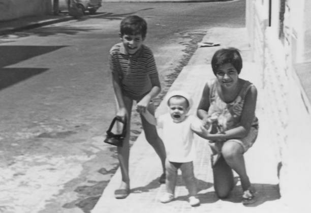 Imagem a preto e branco tirada nos anos 60: crianças Irmãos a posar juntos - foto de acervo