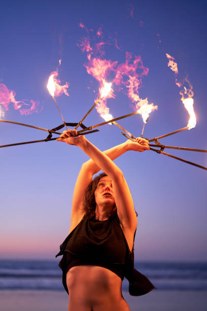 istock latin young woman does performance with fire on the beach at night 1438709105