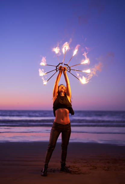 istock latin young woman does performance with fire on the beach at night 1438709113