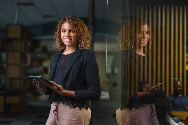 Beautiful Young Transgender Female Secretary Working With A Digital Tablet At The Office stock photo