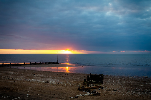 The beach at Hunstanton on the West coast of Norfolk, Eastern England, at sunset. Across The Wash, Lincolnshire is just visible on the horizon.