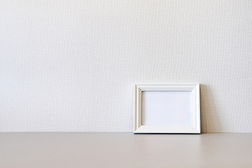 Mock up minimalist home interior with empty white wooden photo frame. Photo with copy space