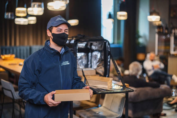 istock Asian Delivery Man Wearing A Protective Face Mask And Holding A Pizza Box 1438719616