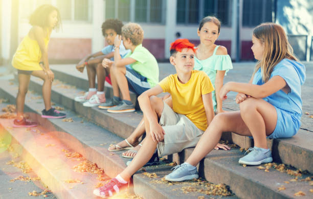 istock Positive tweenagers friendly blabbing while sitting on steps outdoors 1438719778