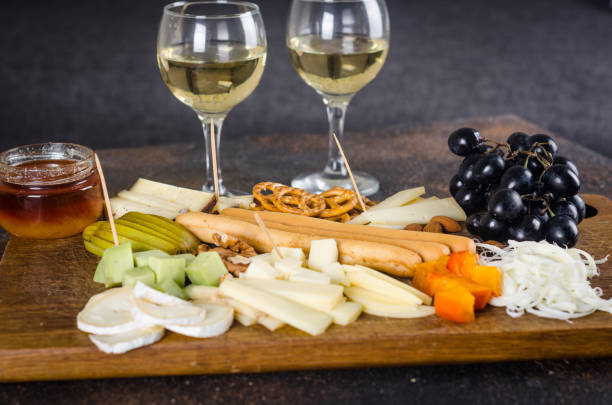istock Cheese plates served with grapes, jam, snacks, crackers and nuts on a wooden board. 1438722925