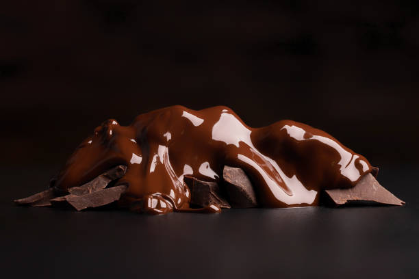 broken pieces pouring with melted chocolate on black table