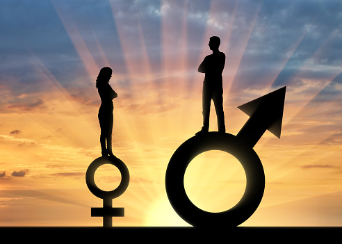 Silhouette of a big man and a small woman standing on gender symbols. The concept of gender inequality and discrimination