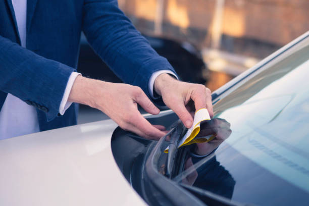 person, die ein parkticket am auto findet - parkvergehen strafzettel fotos stock-fotos und bilder