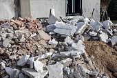 Construction waste from the revitalization of an old house. Pieces of polystyrene and construction rubble are in front of the house for removal