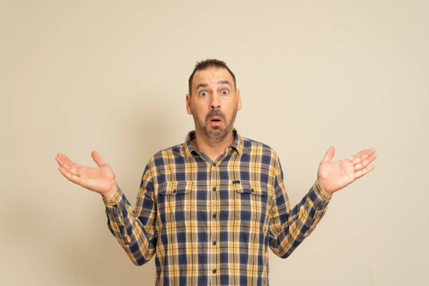 istock Wow. Attractive male half-length front portrait on beige studio backgroud. Emotional surprised bearded man standing with open mouth. Human emotions, facial expression concept. Trendy colors. 1438730320