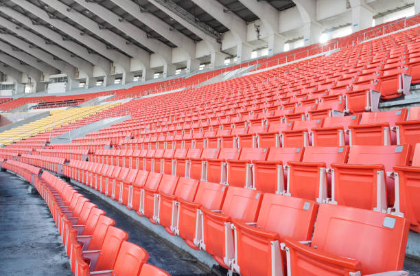 puste pomarańczowe i żółte siedzenia na stadionie, rzędy siedzeń na stadionie piłkarskim - sports venue zdjęcia i obrazy z banku zdjęć