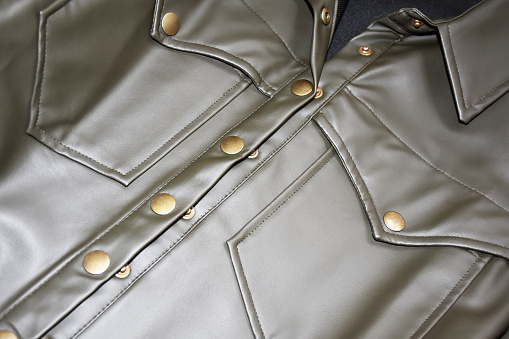 Tailor's hand securing jacket seams with sewing pins while on dressmaker's model, small business salon