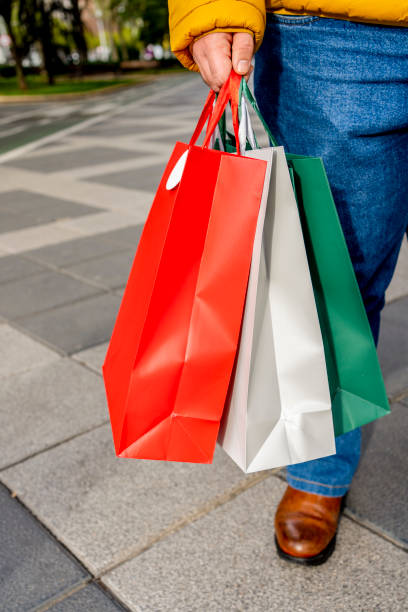 istock male hands holding shopping bags 1438733461