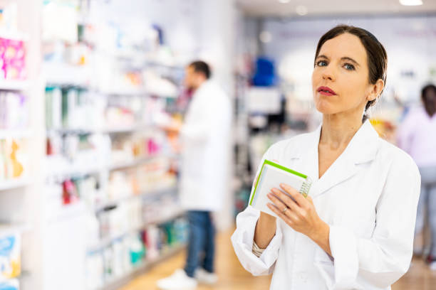istock Woman pharmacist checking medicines, making notes in drugstore 1438735808
